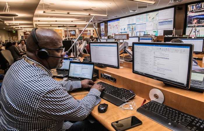 A man engaged with several computer screens showcasing an account planning tool.